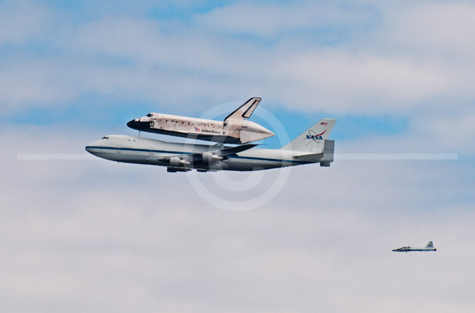 HD_STC-78 - Space Shuttle Discovery mounted on top of a a special Boeing 747 flys over Washington, D.C. on it's way to its new home at the Steven F. Udvar-Hazy Center at Dulles Airport. T-38 chase plane which accompanied Shuttle from Florida can be seen in lower right-hand corner. HD_STC-78 - Space Shuttle Discovery mounted on top of a a special Boeing 747 flys over Washington, D.C. on it's way to its new home at the Steven F. Udvar-Hazy Center at Dulles Airport. T-38 chase plane which accompanied Shuttle from Florida can be seen in lower right-hand corner.